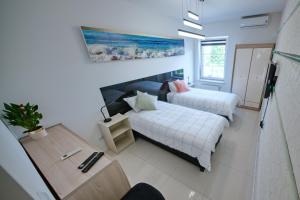 a living room with two beds and a table at Apartament ELITE PREMIUM Giżycko - 200m do plaża ,port, centrum in Giżycko