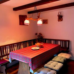 a dining room with a table with a red checkered table cloth at Zlatiborska kuća u šumi in Dobroselica