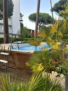 a pool with a table and chairs and plants at Hotel B&B Des Bains Milano Marittima in Milano Marittima