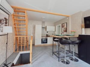 a small kitchen with a table and stools in a room at Apartman Thermea in Krapinske Toplice