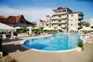 uma grande piscina em frente a um prédio em Godija Hotel & Suites em Velipoja