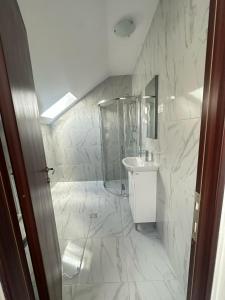 a white bathroom with a sink and a shower at Prestige Accommodation & Wellness in Predeal +19 photos