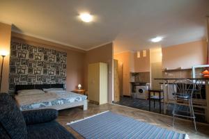 a bedroom with a bed and a living room with a kitchen at Dolce Rita Apartman in Budapest