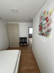 a bedroom with a bed and a painting on the wall at Svečių namai PAS MEŠKĄ in Karklė