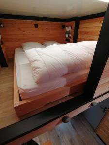 a large bed in a room with a wooden frame at Petit cocon centre MONT DORE in Le Mont-Dore