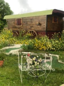 a garden with a table with flowers in the grass at Roulotte au bord du canal du midi argeliers in Argeliers