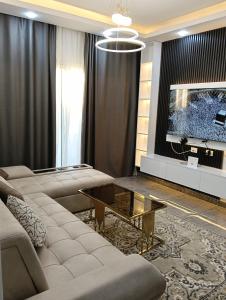 沙姆沙伊赫Suite Deluxe Vip Sharm El Sheik的客厅里有一张沙发和一台电视