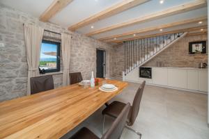 a dining room with a wooden table and chairs at Hideaway Stonehouse pool for 2 Dalmatia Imotski in Medvidovići