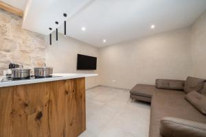 a living room with a couch and a kitchen at Hideaway Stonehouse pool for 2 Dalmatia Imotski in Medvidovići