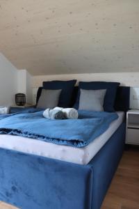a large blue bed with two towels on it at cozy cube 1 Luxury Apartments, nah an der Messe, 30 Minuten zu den Bergen und Seen, 20 Minuten nach München in Glonn