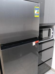 沙姆沙伊赫Suite Deluxe Vip Sharm El Sheik的不锈钢冰箱,上面有微波炉