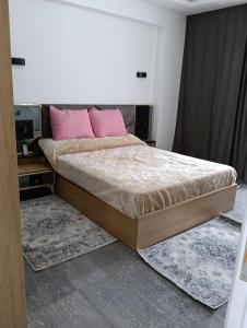 沙姆沙伊赫Suite Deluxe Vip Sharm El Sheik的一间卧室，里面有一张大床，床上放着粉色的枕头。 更多26张照片