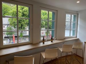 a bar with white chairs and windows at Ferienhaus Schröder OM 3 Altstadt in Monschau +22 photos