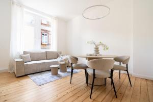 a living room with a table and a couch at 2BR Apartment - ZENTRAL - MODERN - WIFI - KAFFEE - BUSINESS - NETFLIX in Wiesbaden