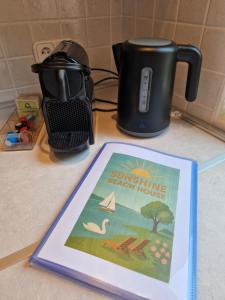 a book sitting on a counter next to a coffee pot at Sunshine Beach House, DIREKT AM SEE, eigenes BOOT, PRIVATE BEACH, Grill, WLAN in Szántód
