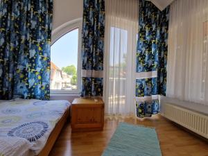 a bedroom with a bed and a large window at Sunshine Beach House, DIREKT AM SEE, eigenes BOOT, PRIVATE BEACH, Grill, WLAN in Szántód