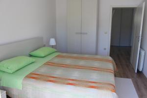 a bedroom with a large bed with green pillows at Apartment Aleksandar in Mošćenička Draga