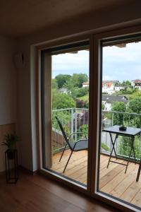 a room with a sliding glass door with a table on a deck at cozy cube 1 Luxury Apartments, nah an der Messe, 30 Minuten zu den Bergen und Seen, 20 Minuten nach München in Glonn