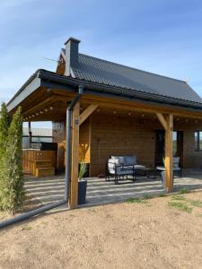ein großer Holzpavillon mit Dach auf einer Terrasse in der Unterkunft Domek w Budzie Ruskiej in Buda Ruska + 12 Fotos