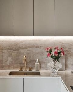 a kitchen sink with a vase with flowers in it at Hanza Tower BOHEMIA 23 Pool & Jacussi & Sauna in Szczecin