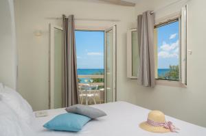 a bedroom with a bed with a view of the ocean at Angel Suites in Agia Anna Naxos