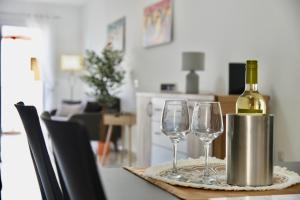 a bottle of wine and two wine glasses on a table at Alight Sauna & SPA Penthouse in Xewkija