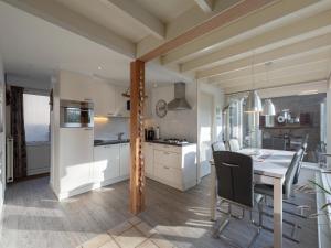une cuisine et une salle à manger avec une table et des chaises dans l'établissement Bungalow in Sint Maartenszee near Beach, à Sint Maartensvlotbrug