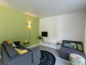 a living room with two couches and a tv at Bungalow in Sint Maartenszee near the beach in Sint Maartensvlotbrug