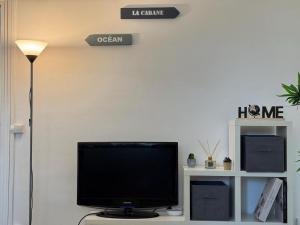 Un televisor de pantalla plana sobre una mesa. en Cozy appartement 2 chambres au coeur de Palaiseau 8min RER B à pieds, en Palaiseau