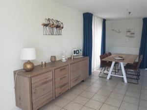 a living room with a table and a dining room at Lovely bungalow with garden in Breskens