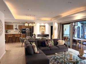 a living room with a couch and a dining room at ORCHID Villa luxueuse avec piscine privée- A 600m de la plage in Pereybere