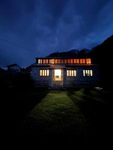 a house lit up at night with its lights on at The Walnut Tree Lodge, Naltar in Jugut
