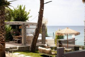 a patio with a table and chairs and the ocean at Ktima Papaoikonomou in Potos