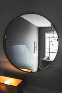 a round mirror on a wall in a bathroom at Reykjavík Rainbow Guesthouse in Reykjavík