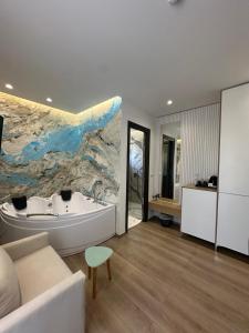 a bathroom with a white tub and a large painting on the wall at Ilio Boutique Hotel in Ksamil