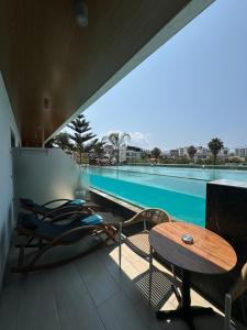 a balcony with a table and chairs and a swimming pool at Ilio Boutique Hotel in Ksamil