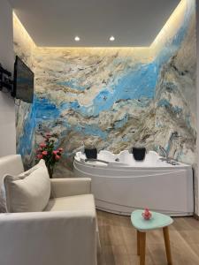 a living room with a white tub and a painting at Ilio Boutique Hotel in Ksamil