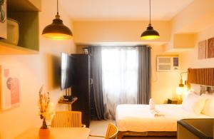 a bedroom with a bed and a window and a table at Casa - Downtown Studio Hideaway in Horizons 101 Cebu in Cebu City +3 photos