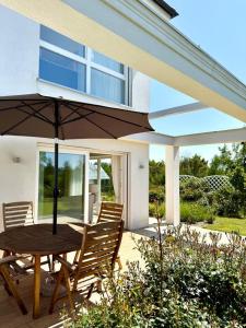 a wooden table and chairs with an umbrella on a patio at Villa Mare in Gdańsk