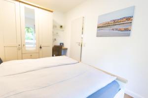 a bedroom with a bed and a painting on the wall at Reede 5 in Wangerooge