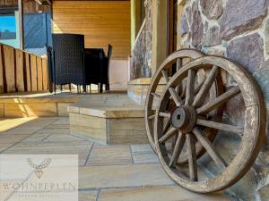 a wooden wagon wheel on the outside of a building at Wohnperle Bauernhaus Meusegast in Dohna
