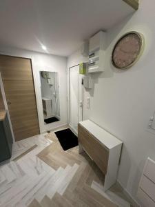 ein Bad mit einer Uhr an der Wand und einer Tür in der Unterkunft Studio indépendant proche de Paris in Vitry-sur-Seine