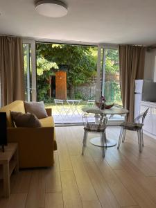 a living room with a couch and a table at Monolocale con giardino in Villa Opicina