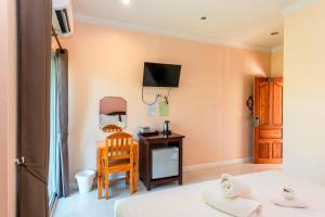 a room with a bed and a desk and a tv at Wangka Resort in Sangkhla Buri