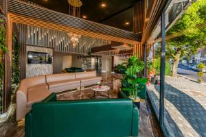 a living room with a couch and some plants at Airport Waves Hotel in Arnavutköy