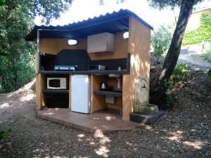a small kitchen in a shed in a yard at Chez Nat et JC in Eccica-Suarella