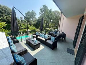 patio z kanapami, stołem i krzesłami w obiekcie LightBlue w mieście Marina di Massa