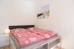 ein Bett mit rosa Bettwäsche darüber in einem Zimmer in der Unterkunft Vienna Living Apartments - Kempelengasse in Wien