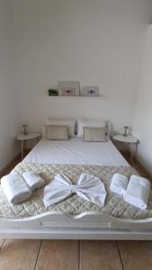 a white bed with two white towels and a bow on it at Eleor in Siviri