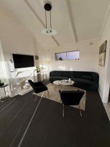 a living room with a couch and a table and chairs at BEACHSIDE UNIT WITH OCEAN VIEWS West Beach in West Beach